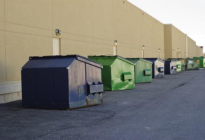 construction workers loading debris into dumpsters on a worksite in Mcnary, AZ